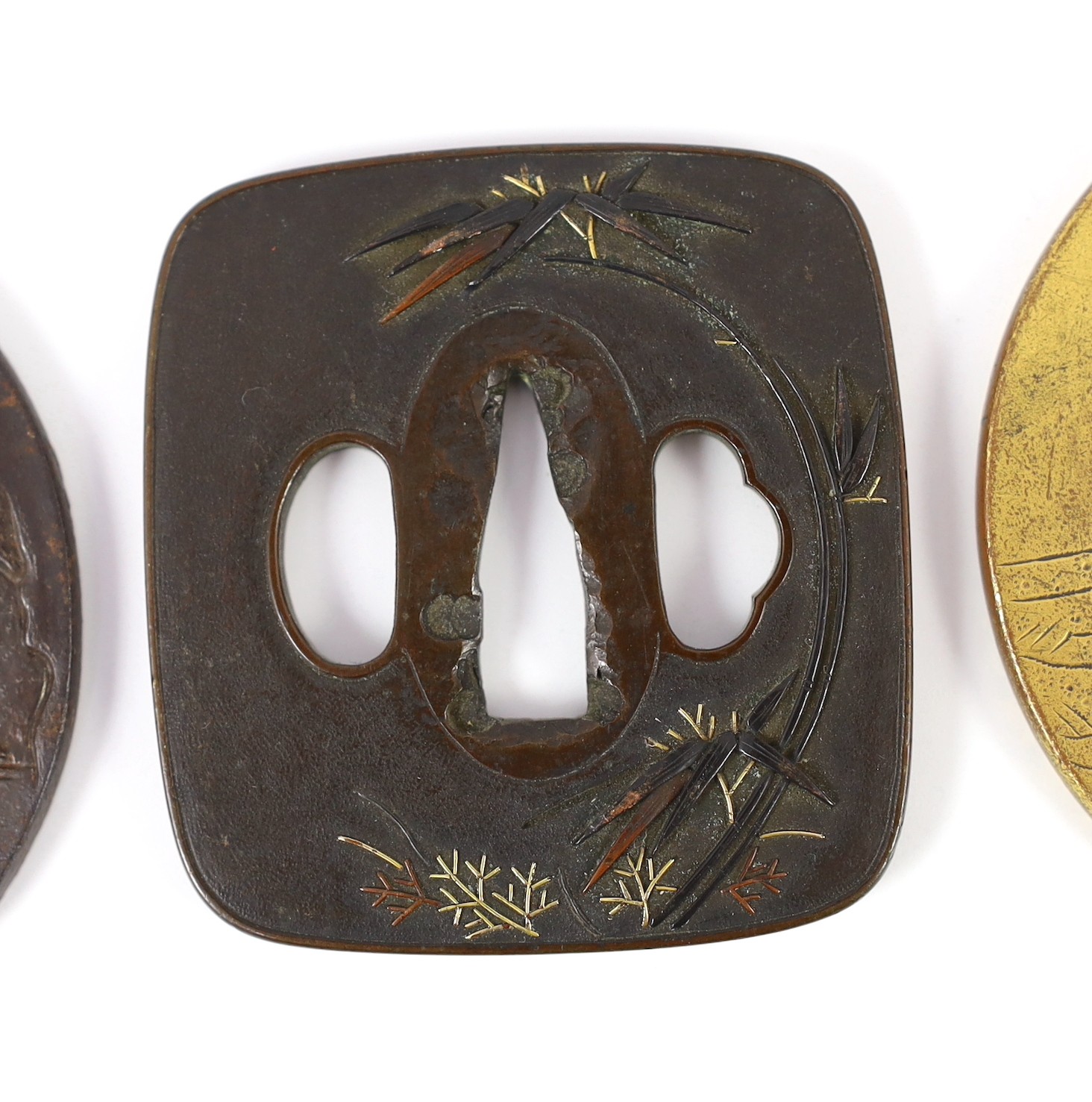 A group of Japanese bronze, iron and mixed metal tsuba and a kozuka knife handle, 19th century